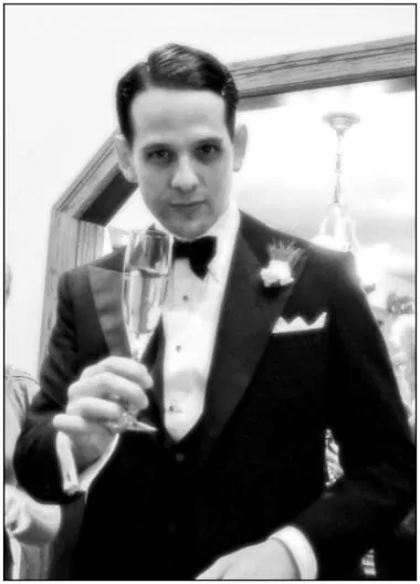 Sven Raphael Schneider in Tuxedo toasting the viewer with a champagne flute