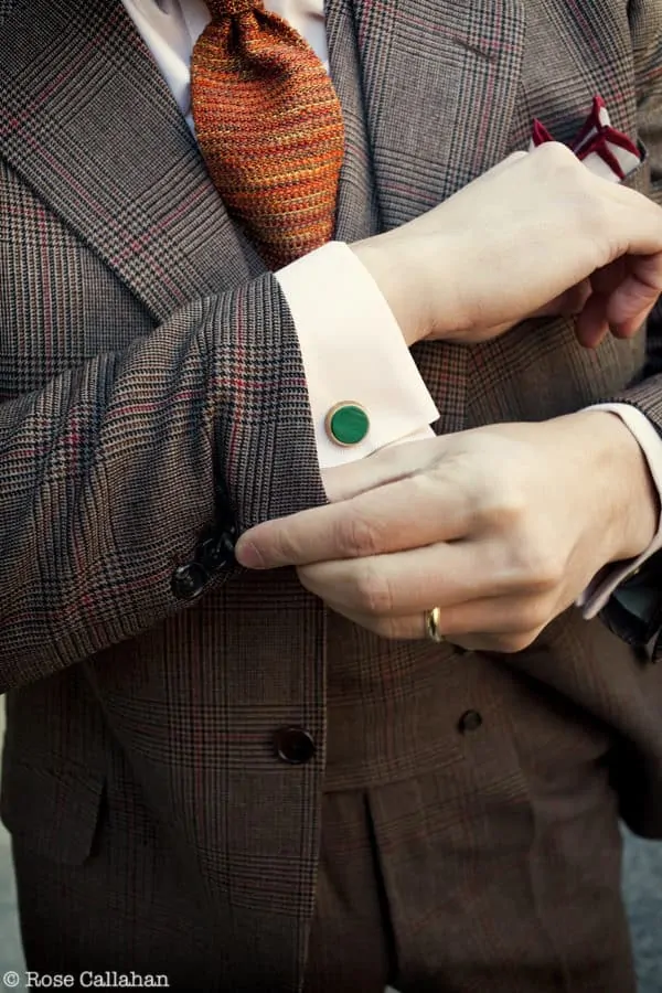 Closeup of the outfit with the Hussmuller suit, pale orange shirt, orange mottled knit tie, and malachite green cuffflinks