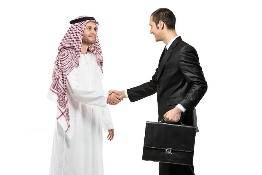 An Arab person shaking hands with a businessman