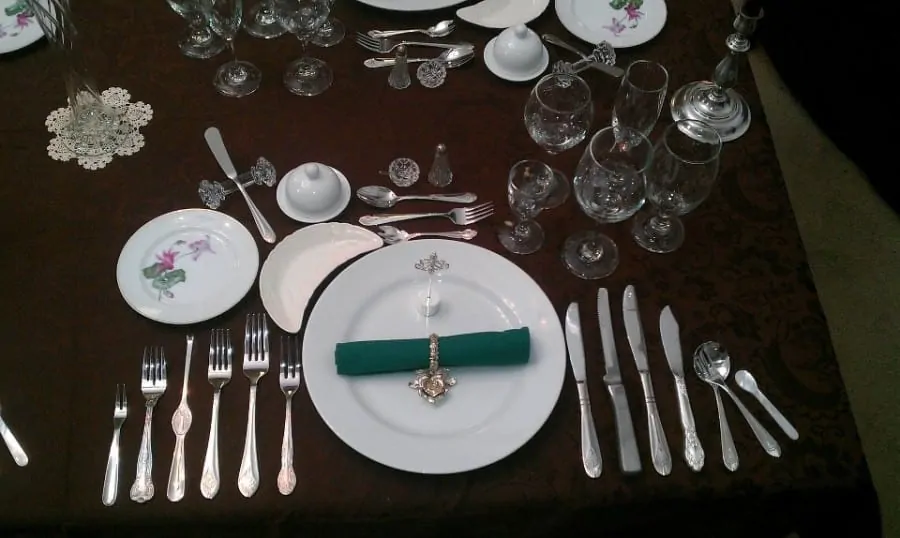 Formal place setting for 12 with bone dish to the left of the charger