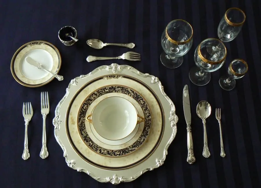 Formal place setting with oyster fork on the right and dessert fork and spoon above the charger