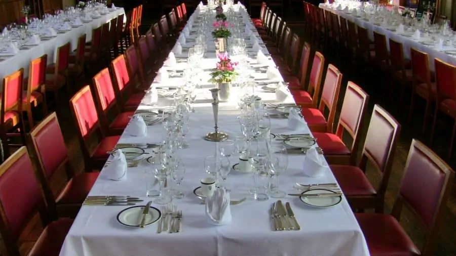 Place settings at a large formal dinner. The host and hostess may be seated at another table