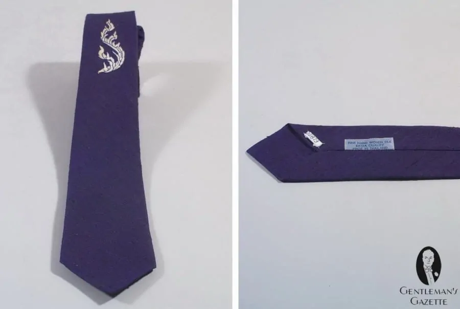 Hand woven Shantung silk in dark blue made into a tie with white embroidery