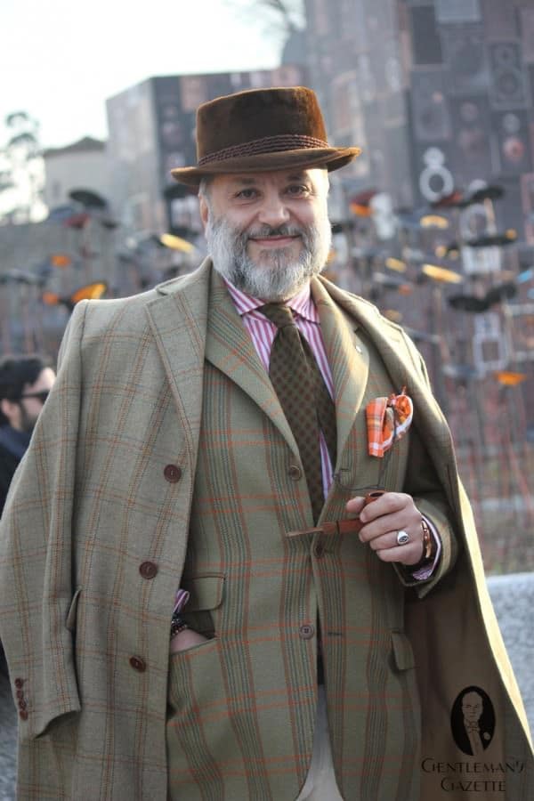 A photograph of Gianni Fontana in an outfit dominated by green plaids. Just the jacket or the coat work well but not both together