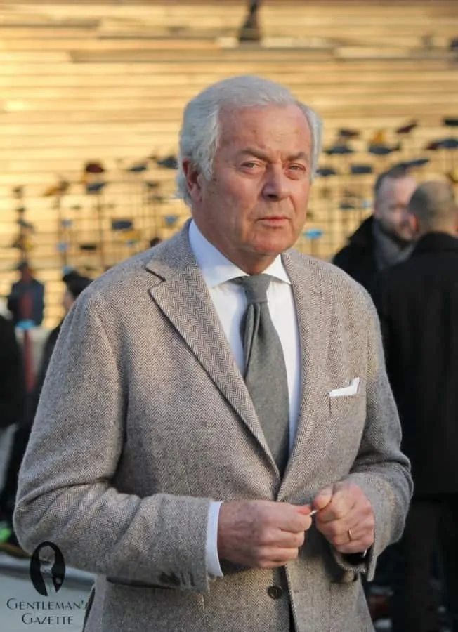 A photograph of a man wearing a Spread collar, muted herringbone sportcoat, grey woven wool or cashmere tie - note the spalla camicia which looks just like a shirt shoulder and the drape
