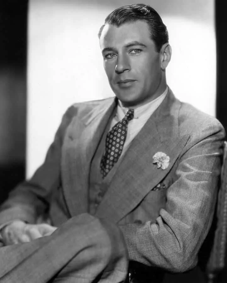 Gary Cooper in a 3 piece suit in grey with mini carnation boutonniere