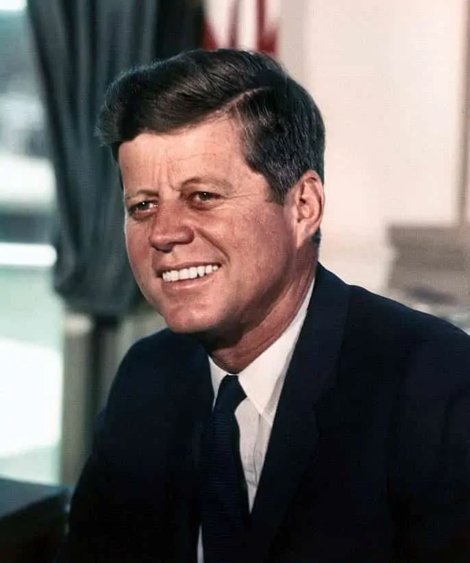 John F. Kennedy in White House in a navy jacket, white dress shirt and tie