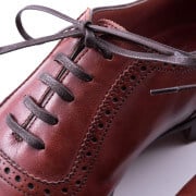 Dark brown shoelaces worn on an oxblood shoe