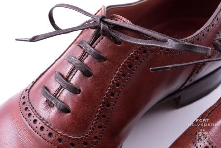 Dark brown shoelaces worn on an oxblood shoe