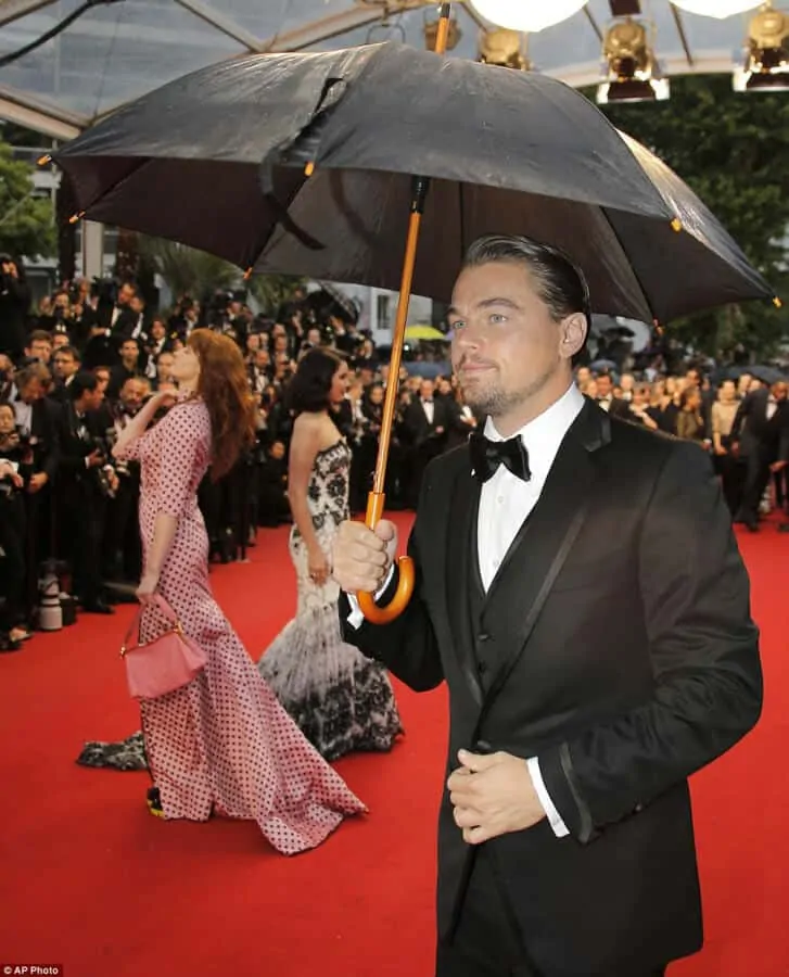 Leonardo DiCaprio using an umbrella at a red carpet event