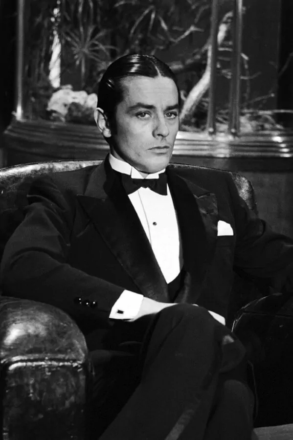 Alain Delon with middle part, one stuf shirt front and black cuff links with wing collar