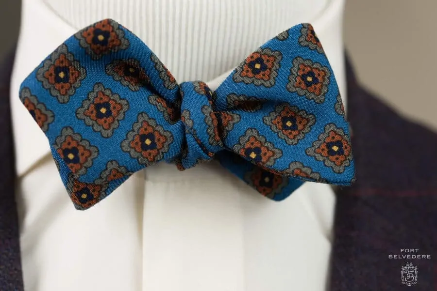 Close up details when worn Wool Challis Bow Tie in Turquoise Blue with Green, Orange, Navy & Yellow Pattern - Fort Belvedere