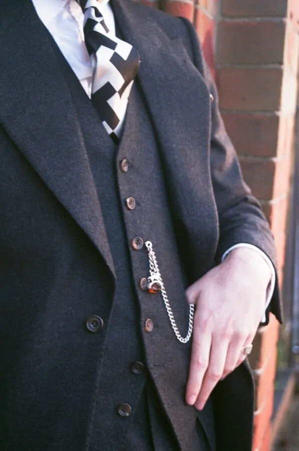 Note, Aleks wear an Albert Watch Chain with FOB and keeps the bottom two buttons of his jacket unbuttoned
