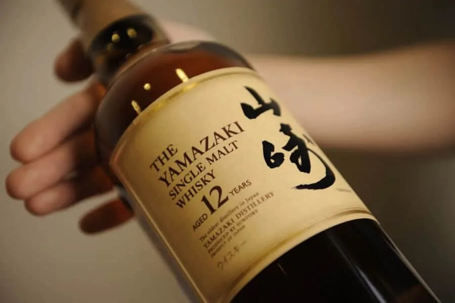 An employee holds a bottle of Suntory Holdings Ltd.'s Yamazaki whisky at the company's Yamazaki distillery in Shimamoto, Osaka, Japan, on Friday, Sept. 13, 2013. Suntory is a household name in Japan, selling drinks from canned coffee to beer, sponsoring TV shows, and operating its own fine art gallery and concert hall. Suntorys Japanese single malt whiskies now regularly win top international awards. Photographer: Akio Kon/Bloomberg via Getty Images