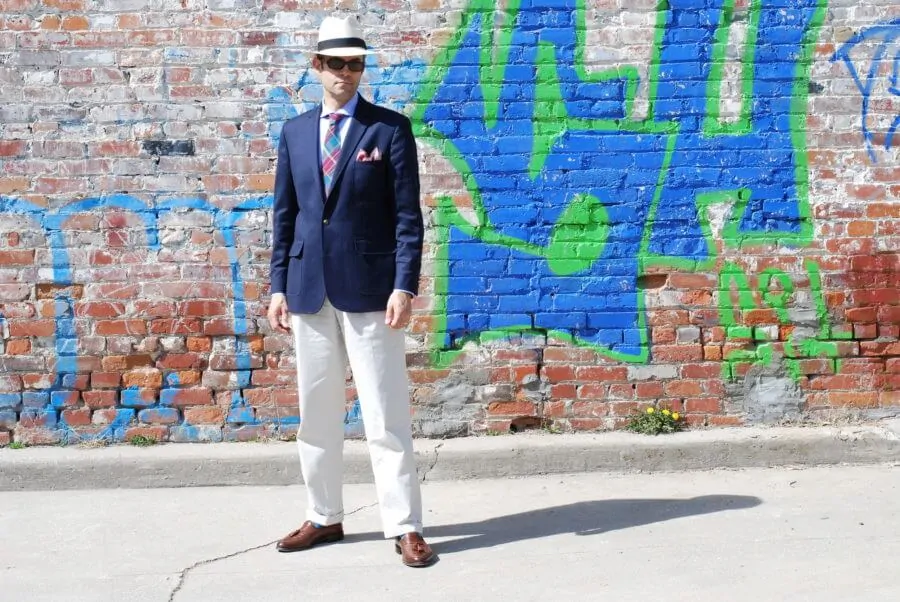 Pedro Mendes wearing a blazer with patch pockets, Madras tie, Panama hat and tassel loafers