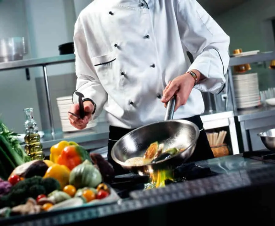 A chef using his cookware in the kitchen