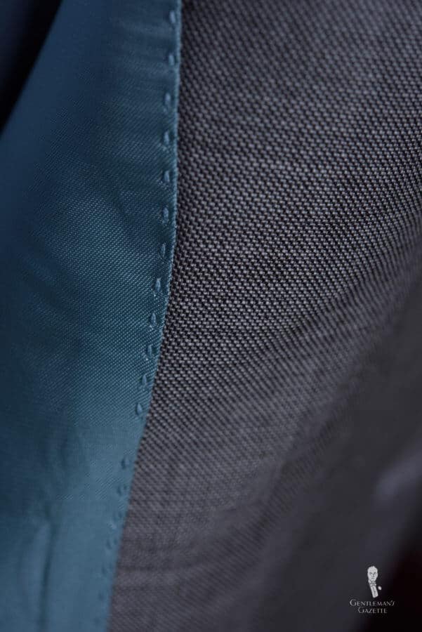 The decorative stitching is machine-made even though it is made to look like handwork - typical of a $500 suit