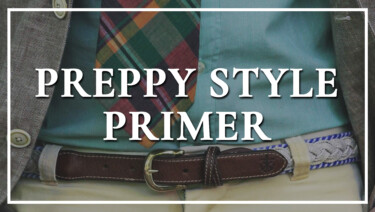 A close-up of a typical preppy outfit; Madras necktie, woven belt, chino trousers, casual blazer, and OCBD shirt. Text reads, "Preppy Style Primer"