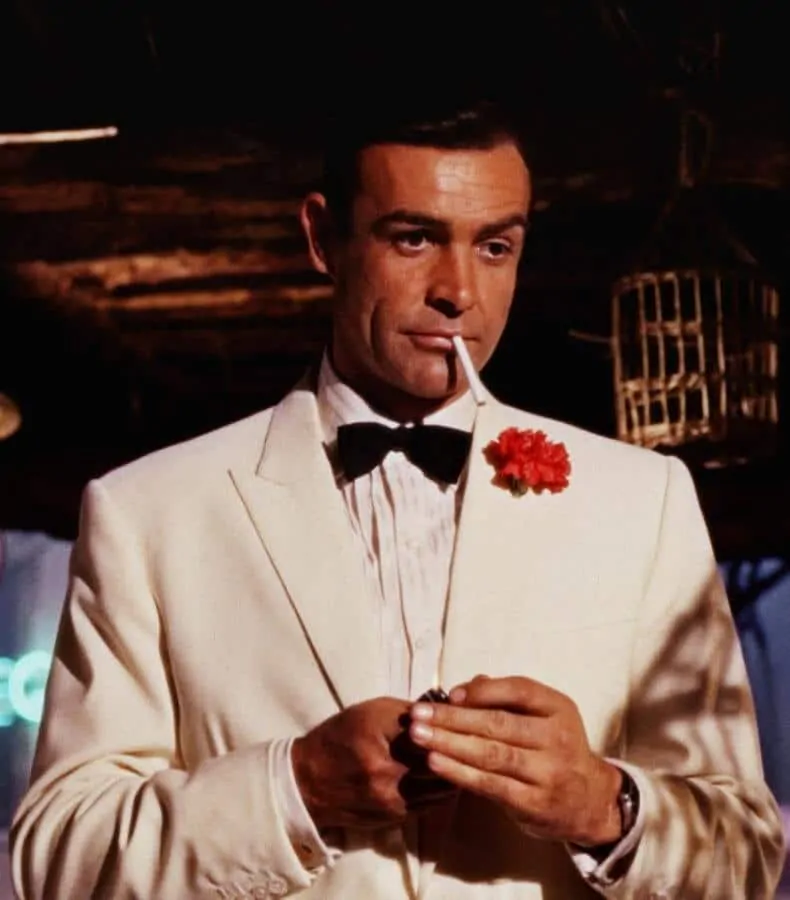 Sean Connery as James Bond wearing a white dinner jacket with a red carnation boutonniere