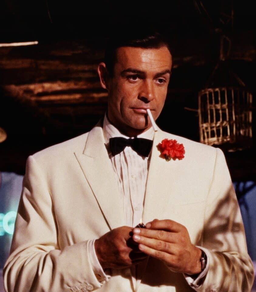 Sean Connery as James Bond wearing a white dinner jacket with a red carnation boutonniere