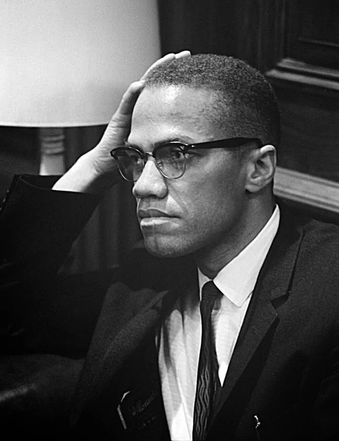 Malcolm X wearing his distinguished browline glasses