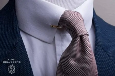 A shirt front and tie worn with a collar clip