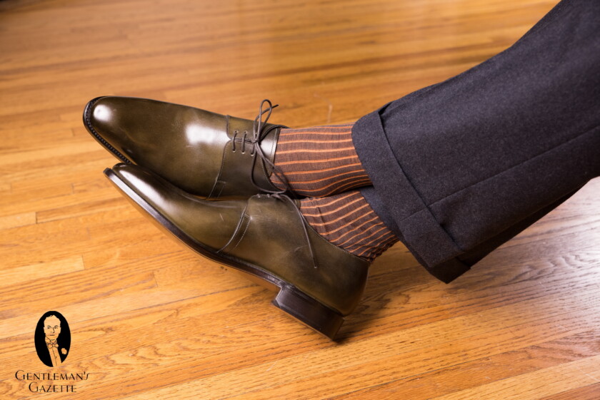 Orange and charcoal shadow stripedsocks with dark green shoes