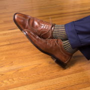 Brown Norwegian shoes with navy and yellow socks paired with navy pants