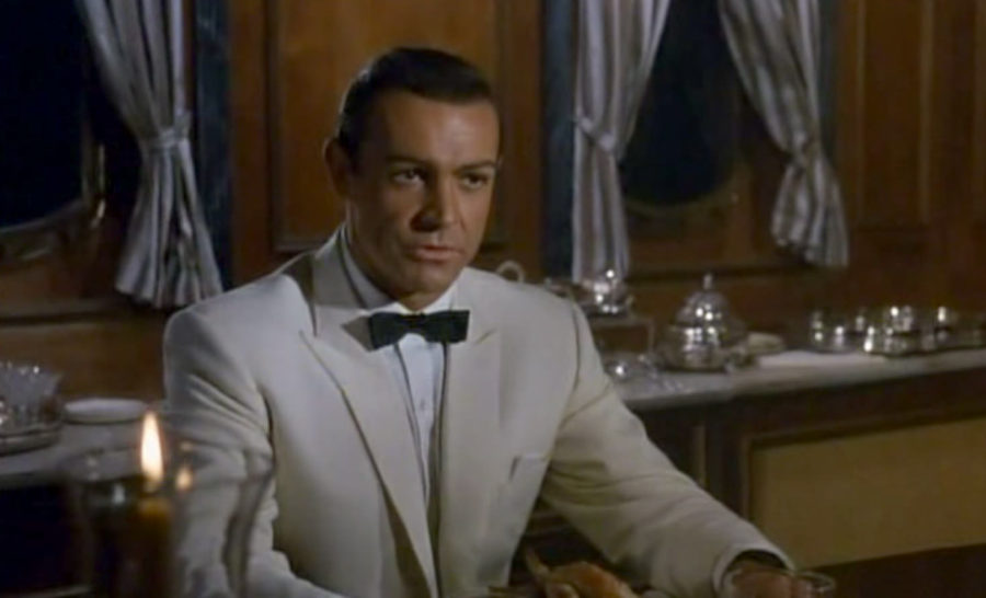 Sean Connery wearing an ivory dinner jacket with a black batwing bow tie in Woman of Straw; the same jacket was famously worn in Goldfinger.