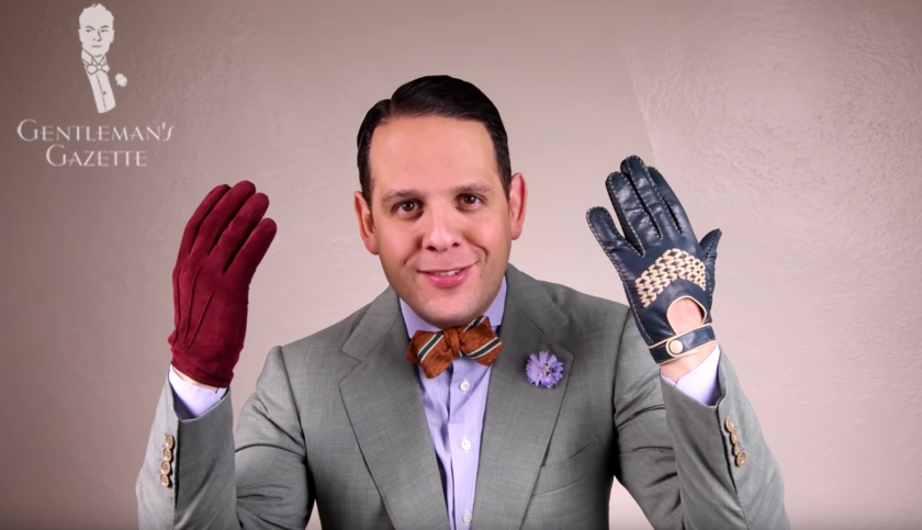 A photograph in which Raphael demonstrates the difference in length between regular gloves (left) and driving gloves (right). 