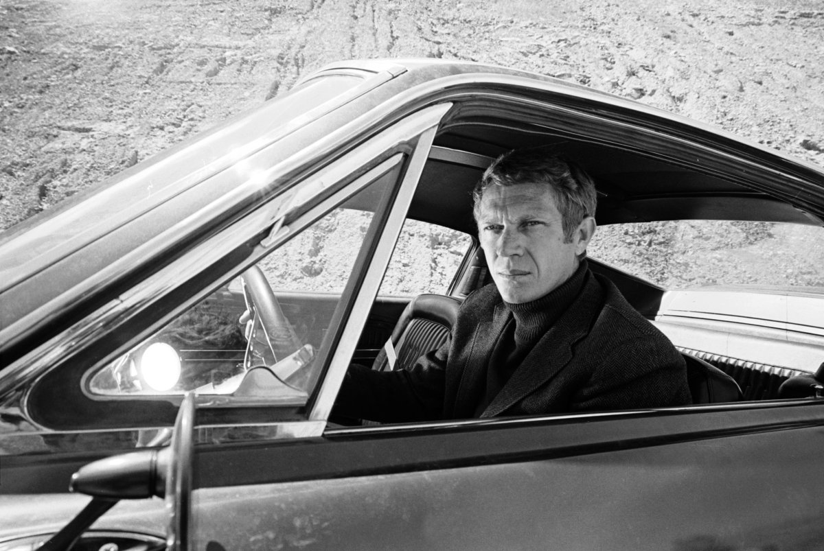 McQueen wearing a monochrome turtleneck with his jacket, a style that is popular again right now