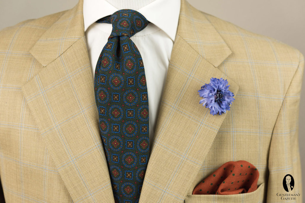 The dark, subtly patterned tie helps to ground this lighter colored, patterned jacket