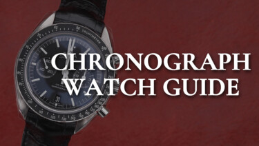 An Omega Speedmaster watch on a black strap sits on a background of red leather