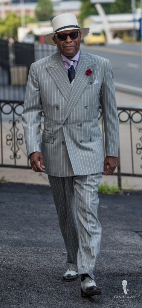 Dr Andre Churchwell with Panama hat, and striped suit with boutonniere and spectators