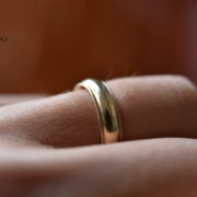 A gold wedding band on a finger