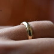 A gold wedding band on a finger