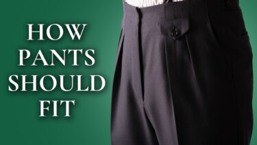 A pair of full-cut, pleated navy dress trousers; text reads, "How Pants Should Fit"