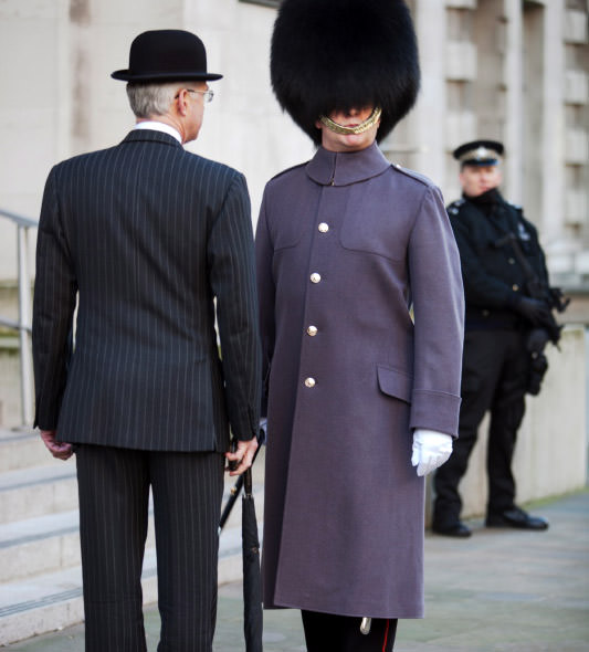 The black bowler hat with a pinstripe suit and umbrella creates a quintessentially British look
