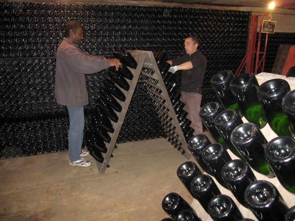 Champagne bottles are turned in the rack