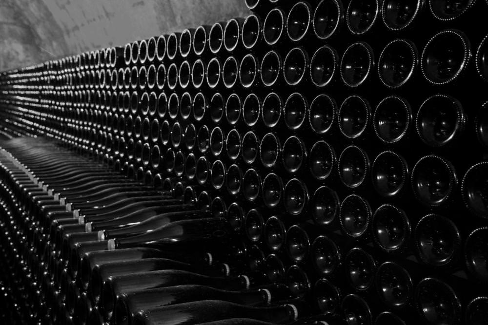 Champagne bottles resting on lees in the caves