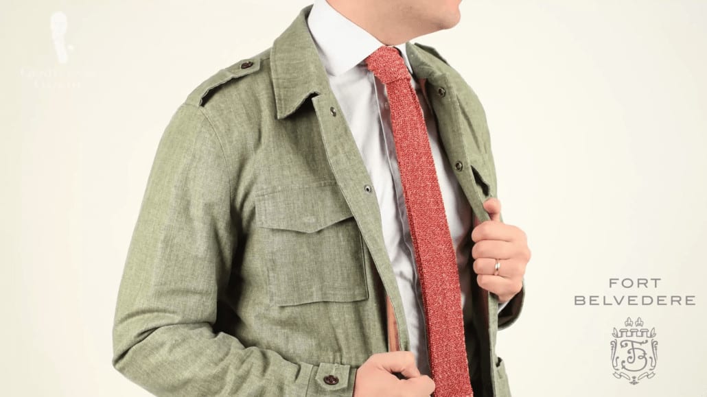 A green linen jacket and white dree shirt accessorized with knit tie in moltted orange and brown from Fort Belvedere.