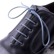 Blue shoeces worn on a black shoe