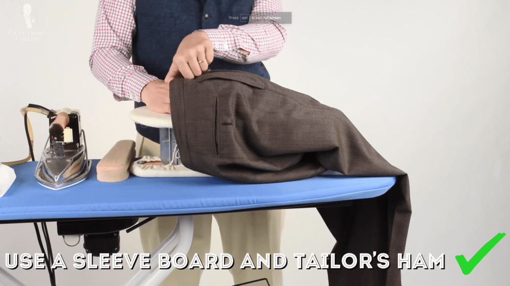 Pressing trousers on sleeve board