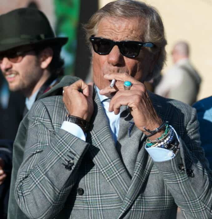 Lino displaying sprezzatura sunglasses open shirt cuffs wristbands ring sunglasses cigarette jacket on the shoulders sleeve cuffs undone