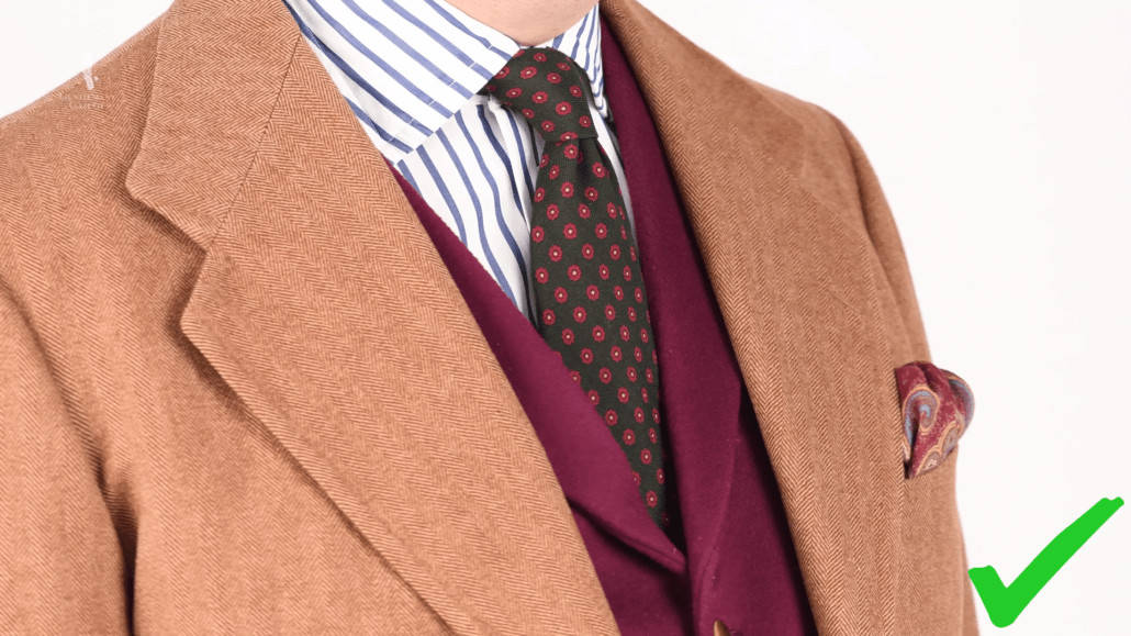Raphael wearing a donegal tweed suit in brown, striped shirt and burgundy vest
