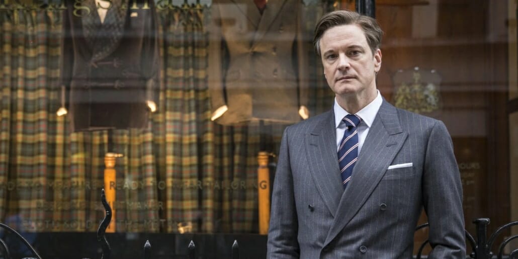 Colin Firth on the set of "Kingsman: The Secret Service" wearing a classic British suit with padded shoulders.