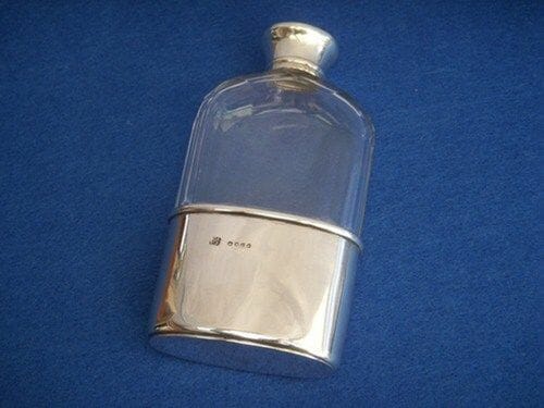An English glass and silver hip flask