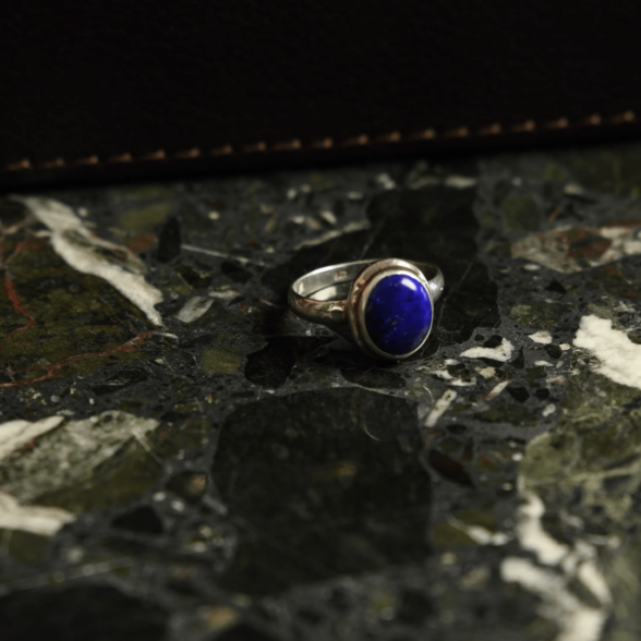 A photograph of a dark blue lapis lazuli in a sterling silver ring