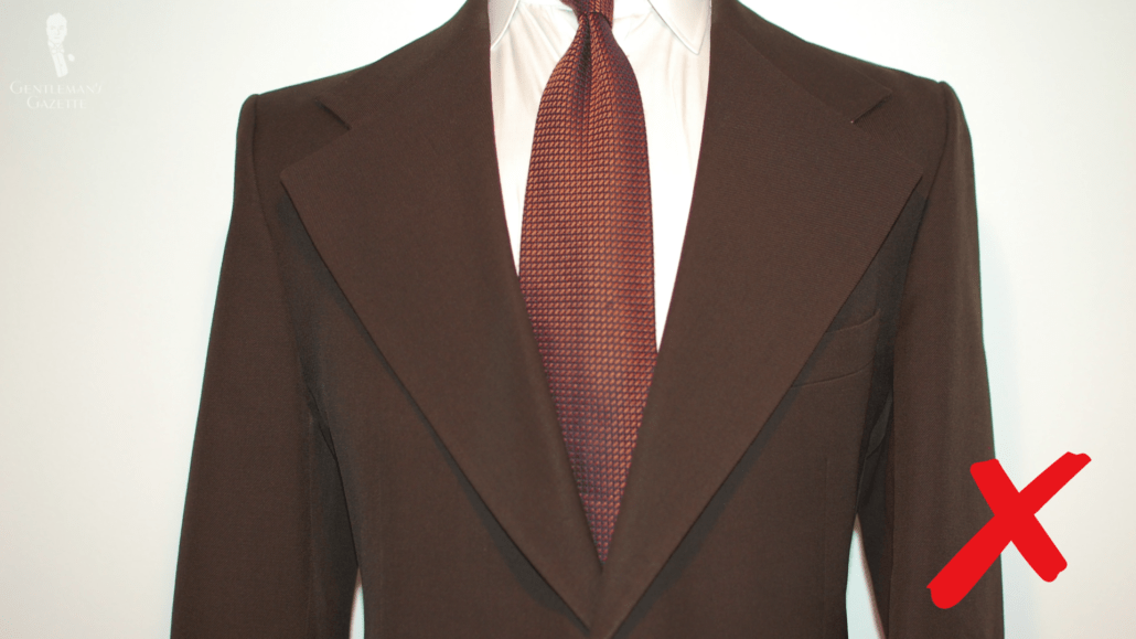 Avoid Lapels That Are Too Wide Dark brown suit jacket with wide lapel