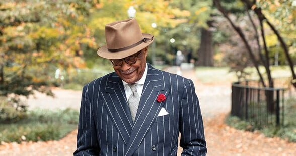 Dr. Andre Churchwell with Panama hat, and striped suit other accessories